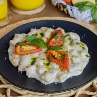 Ñoquis de calabaza con salsa de queso, tomate asado y pesto